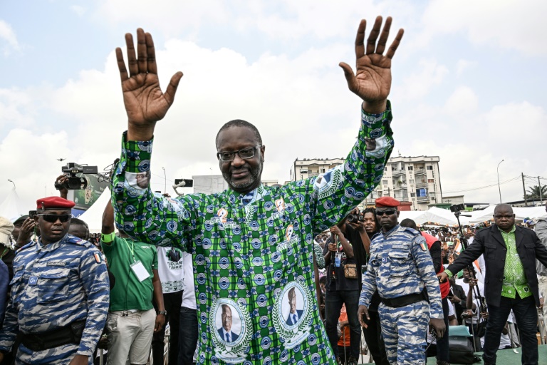Tidjane Thiam (c), président du Parti démocratique de Côte d'Ivoire (PDCI), salue ses partisans à son arrivée pour un meeting de mobilisation pour l'élection présidentielle d'octobre 2025, à Yopougon, commune populaire d'Abidjan, le 15 février 2025