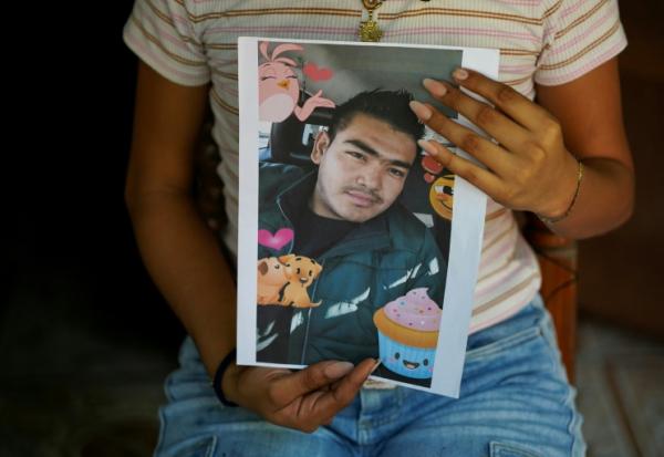 Jade, 16 ans, tient dans ses mains le portrait de son père Jose Roger Urquilla, le 3 décembre 2025 à El Rosario, au Salvador.
