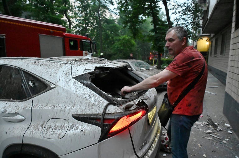 Un homme retrouve sa voiture endommagée après une série d'attaques russes contre la ville de Kharkiv, dans l'est de l'Ukraine, le 7 juin 2025