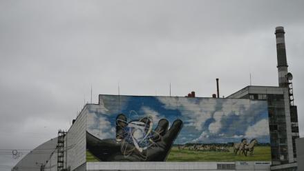 La centrale nucléaire de Tchernobyl et, en arrière plan, une partie du nouveau confinement de sécurité, un dôme métallique recouvrant le sarcophage du quatrième réacteur détruit lors de l'invasion russe de l'Ukraine, le 9 avril 2026 à Tchernobyl