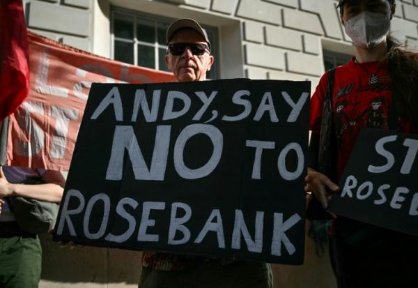 Un homme tient une pancarte contre le projet de champ pétrolier Rosebank, en mer du Nord; au large de l'Écosse, alors que des militants  écologistes manifestent à Londres, le 22 juillet 2026