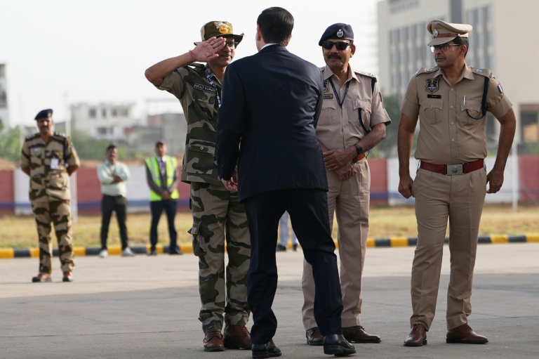 Un responsable indien de la sécurité salue le secrétaire d'Etat américain Marco Rubio avant que celui-ci ne monte à bord de son avion à l'aéroport international de Jaipur, en Inde, le 26 mai 2026