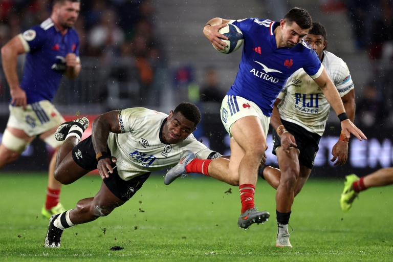 L'arrière du XV de France Thomas Ramos (D) échappe au plaquage du Fidjien Josua Tuisova lors du match international remporté par les Bleus (34-21), le 15 novembre 2025 à Bordeaux