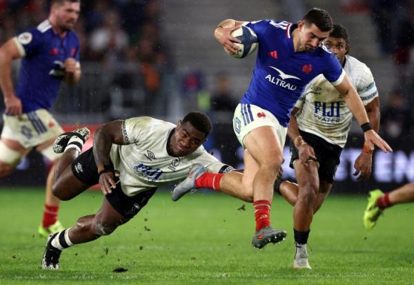 L'arrière du XV de France Thomas Ramos (D) échappe au plaquage du Fidjien Josua Tuisova lors du match international remporté par les Bleus (34-21), le 15 novembre 2025 à Bordeaux