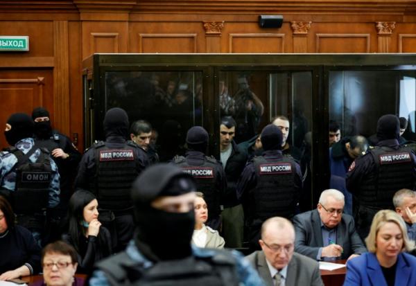 Les accusés, soupçonnés d'implication dans l'attentat perpétré en 2024 à la salle de concert Crocus City Hall, dans des box vitrés avant l'annonce de leur verdict par un tribunal de Moscou, le 12 mars 2026