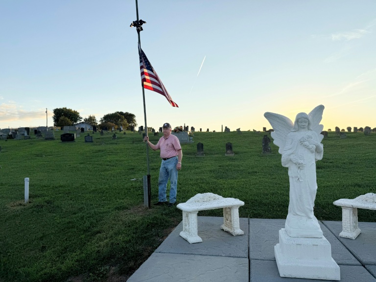 A man who says he knew Dolly Parton stands with a flag flying at half-staff in Sevierville, Tennessee