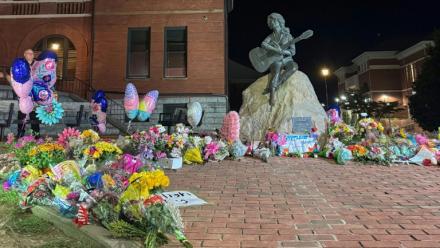 Au pied de la statue de Dolly Parton, des fleurs déposées en hommage le 25 août 2026 à Sevierville (Etats-Unis)