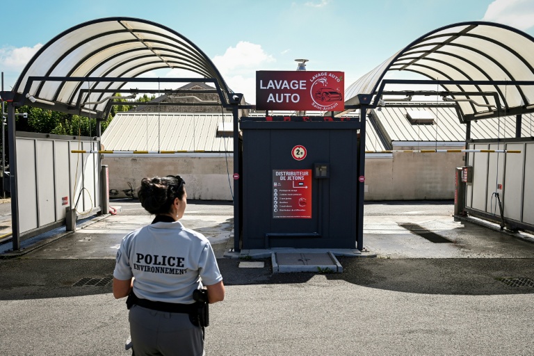 La police de l'environnement inspecte une station de lavage automobile à Saint-Quentin-en-Yvelines, près de Paris, le 5 août 2022