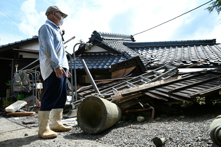 Un homme regarde sa maison effondrée à Hikawa, dans la préfecture de Kumamoto, le 30 juillet 2026, après le séisme qui a frappé le sud-ouest du Japon le 28 juillet