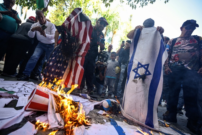Des manifestants brûlent des drapeaux américains et israéliens à Caracas, le 24 juillet 2026