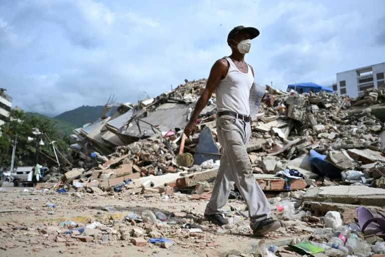 Un homme marche parmi les ruines d'immeubles effondrés à Caraballeda, dans l'Etat de La Guaira, au Venezuela, le 8 juillet 2026, à la suite du puissant double séisme