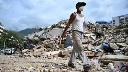 Un homme marche parmi les ruines d'immeubles effondrés à Caraballeda, dans l'Etat de La Guaira, au Venezuela, le 8 juillet 2026, à la suite du puissant double séisme