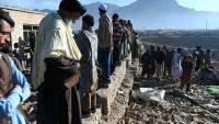 Des habitants rassemblés autour d'habitations endommagées après des bombardements, en périphérie de Kaboul, le 13 mars 2026 en Afghanistan