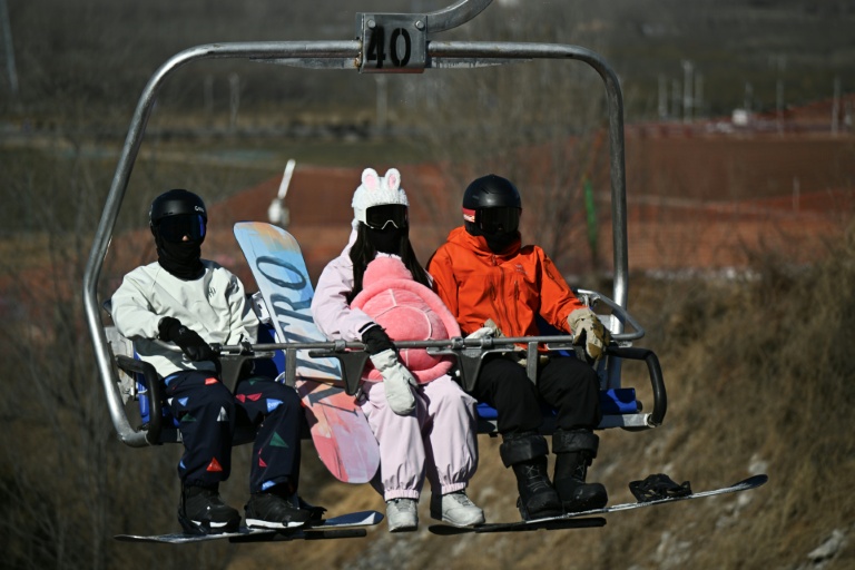 Des skieurs sur un télésiège de la station de ski de Lianhuashan, à la périphérie de Pékin, le 16 février 2026 en Chine