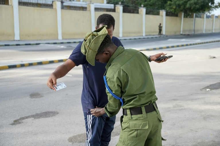 Un membre des forces de sécurité fouille un électeur lors des élections locales à Mogadiscio, le 25 décembre 2025 en Somalie
