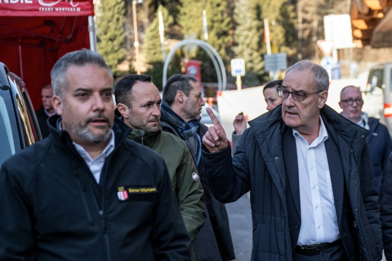 Le président suisse, Guy Parmelin (à droite) inspecte la zone où un incendie a ravagé le bar Le Constellation lors des célébrations du nouvel an à Crans-Montana, le 1er janvier 2026