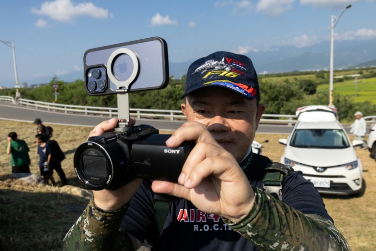 Un passionné d'aviation attend devant la base aérienne de Chihhang l'arrivée des nouveaux avions de chasse F-16V à Taitung, à Taïwan, le 2 octobre 2026
