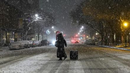 Une personne marche dans les rues enneigées de New York le 22 février 2026, aux Etats-Unis