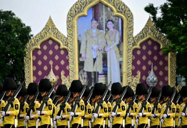 La Garde royale défile devant un portrait du roi de Thaïlande Maha Vajiralongkorn et de la reine Suthida à Bangkok, le 3 décembre 2024