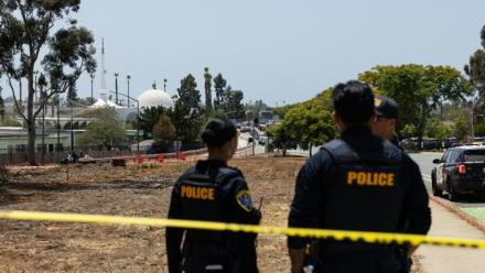 Deux membres des forces de l'ordre près de la mosquée de San Diego, en Californie, où trois personnes ont été tuées et où les deux tireurs présumés ont été retrouvés morts, le 18 mai 2026