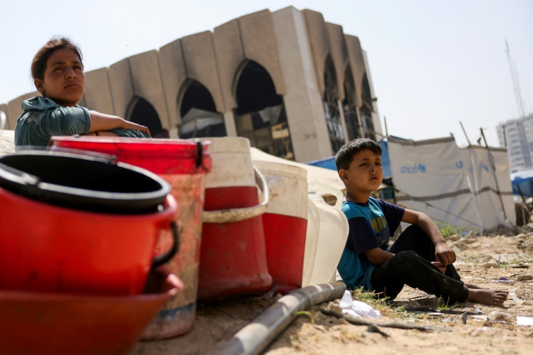 Des habitants déplacés de Gaza à un point de collecte d'eau, dans la ville de Gaza, dans le nord du territoire palestinien, le 20 mai 2025