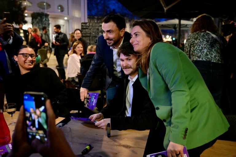 Le maire de Lyon Grégory Doucet (2e g), candidat à sa réélection aux municipales, et la secrétaire nationale des Écologistes, Marine Tondelier (d), posent pour des photos lors d'une distribution de tracts à Lyon, le 5 mars 2026