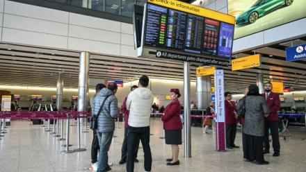 Le personnel de Qatar Airways renseigne des voyageurs à l’aéroport de Londres-Heathrow, le 1er mars 2026, alors que les vols sont gravement perturbés en raison de la guerre au Moyen-Orient