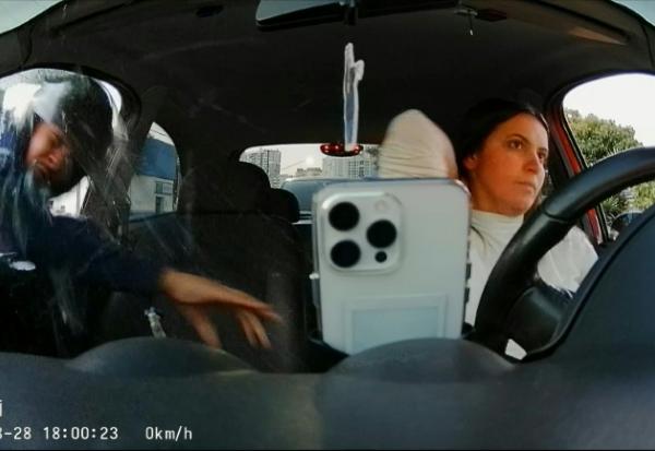 Extrait d'une vidéo prise par une caméra de vidéosurveillance fixée à l'intérieur d'un véhicule montrant un homme fracassant la vitre passager pour s'emparer du téléphone de la conductrice, le 28 août 2026 à Sao Paulo, au Brésil 