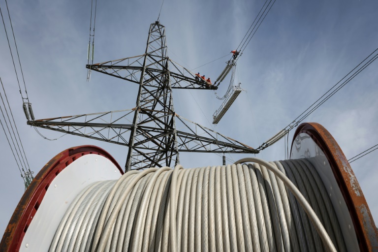 Des apprentis suivent une formation sur un pylône au centre de formation de National Grid à Eakring, dans le centre de l'Angleterre, le 28 avril 2025, perchés à 45 mètres de hauteur