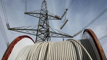 Des apprentis suivent une formation sur un pylône au centre de formation de National Grid à Eakring, dans le centre de l'Angleterre, le 28 avril 2025, perchés à 45 mètres de hauteur
