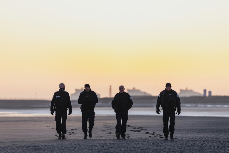 Des policiers français patrouillent sur la plage de Gravelines au lever du soleil afin d'empêcher les migrants de traverser la Manche, à Gravelines, dans le nord de la France, le 14 avril 2026