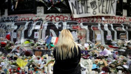 Une femme se recueille devant un mémorial improvisé composé de fleurs, de bougies et de messages, place de la République à Paris, le 17 novembre 2015, en hommage aux victimes des attentats du 13 novembre 2015