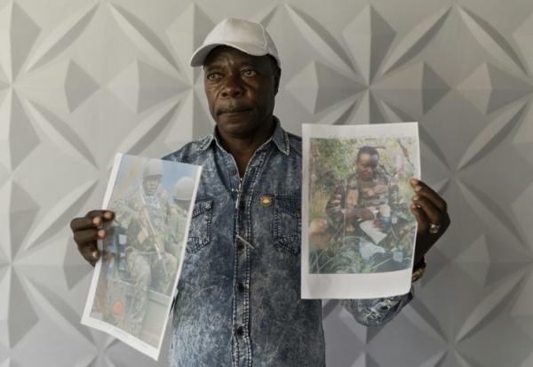 Un proche montre des photos de Kényans enrôlés de force dans l'armée russe en Ukraine lors d'une conférence de presse à Nairobi, le 27 janvier 2026, pour exiger du gouvernement leur rapatriement