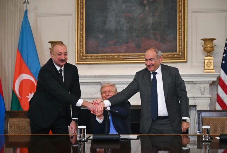 Le président azerbaïdjanais Ilham Aliev (à gauche) et le Premier ministre arménien Nikol Pachinian (à droite) se serrent la main en présence du président américain Donald Trump, le 8 août 2025 à la Maison Blanche