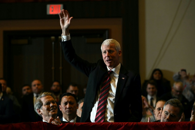 Le ministre américain de l'Energie, Chris Wright, lève la main alors que le président Donald Trump (non visible sur la photo) prononce un discours, en Pennsylvanie, le 9 décembre 2025