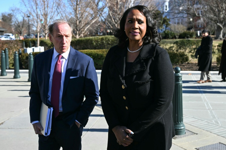 La gouverneure de la Fed Lisa Cook (d), accompagnée d'un avocat, fait une déclaration à la presse devant la Cour suprême américaine, le 21 janvier 2026 à Washington
