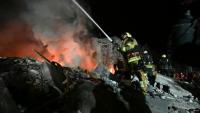 Des pompiers ukrainiens combattent un incendie après une frappe de missile russe sur un immeuble résidentiel à Kharkiv le 7 mars 2026