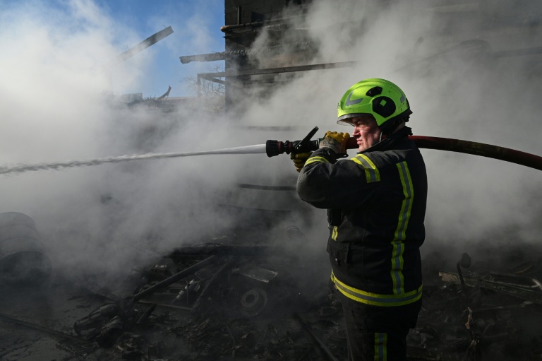 Un pompier sur les lieux d'un incendie après une attaque de missile et de drone dans la localité ukrainienne de Brovary, près de Kiev, le 14 mars 2026  
