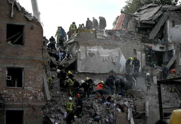 Des secouristes recherchent des survivants dans les décombres d'un immeuble résidentiel après une frappe aérienne russe à Prylouky, le 7 octobre 2026 dans le nord de l'Ukraine