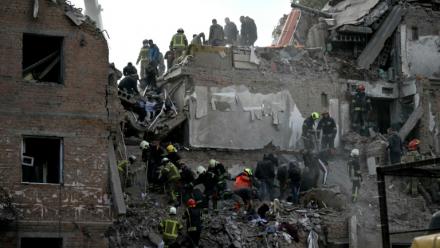 Des secouristes recherchent des survivants dans les décombres d'un immeuble résidentiel après une frappe aérienne russe à Prylouky, le 7 octobre 2026 dans le nord de l'Ukraine
