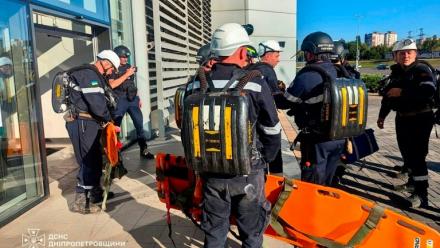 Photo diffusée par le Service d'État ukrainien pour les situations d'urgence, le 21 août 2026, montrant des pompiers luttant contre un incendie sur le site d'un centre commercial endommagé par une frappe russe à Kryvyï Rih, en Ukraine