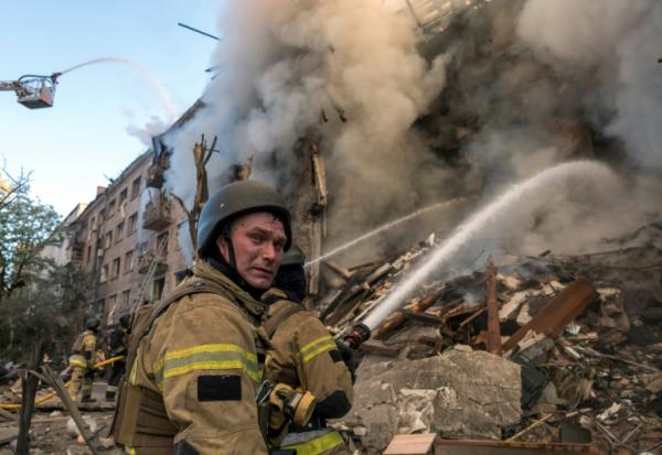 Des pompiers luttent contre un incendie après d'intenses bombardements russes nocturnes qui ont particulièrement visé la capitale ukrainienne, le 24 mai 2026 à Kiev