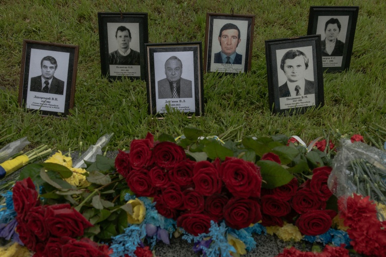 Des fleurs placées devant les portraits de victimes de la catastrophe de Tchernobyl à l'occasion du 40e anniversaire de l'accident, le 26 avril 2026 à Kiev 