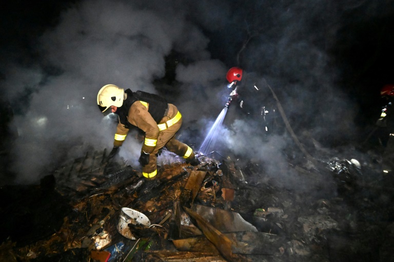 Des secouristes ukrainiens éteignent un incendie dans une maison après une attaque de drones à Kharkiv le 3 mai 2025