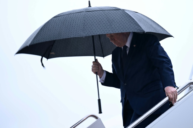 Le président américain Donald Trump tient un parapluie à sa descente de l'avion présidentiel Air Force One à la base Andrews, près de Washington, le 22 mai 2026