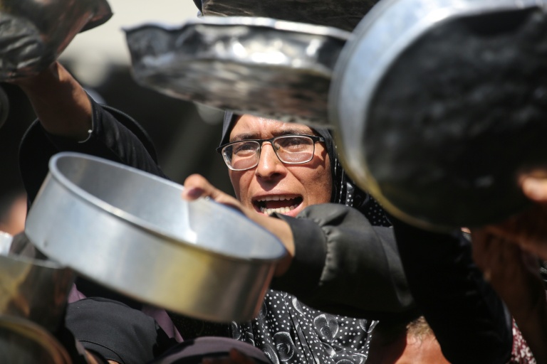 Nihaya Al-Masri (C), une Palestinienne déplacée lors d'une distribution alimentaire à Khan Younès, dans le sud du territoire palestinien, le 6 octobre 2026 
