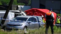 Un corbillard stationné sur le site d'un accident entre un train et un bus scolaire, au passage à niveau de Vierhuizen à Buggenhout, au nord de Bruxelles, le 26 mai 2026 en Belgique
