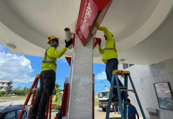 Des ouvriers consolident les panneaux d'une station service avant l'arrivée d'un "super typhon", le 4 juillet 2026 à Saipan, dans les Iles Mariannes du Nord  