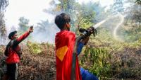 'adolescent indonésien Rudiansyah porte un costume de "Superman" en combattant un incendie, à Palangkaraya, dans le Kalimantan central, le 17 août 2026