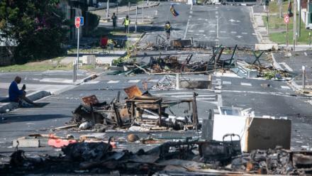 Une rue bloquée par des objets incendiés et des débris, dans le quartier Magenta à Nouméa en Nouvelle-Calédonie, le 18 mai 2024